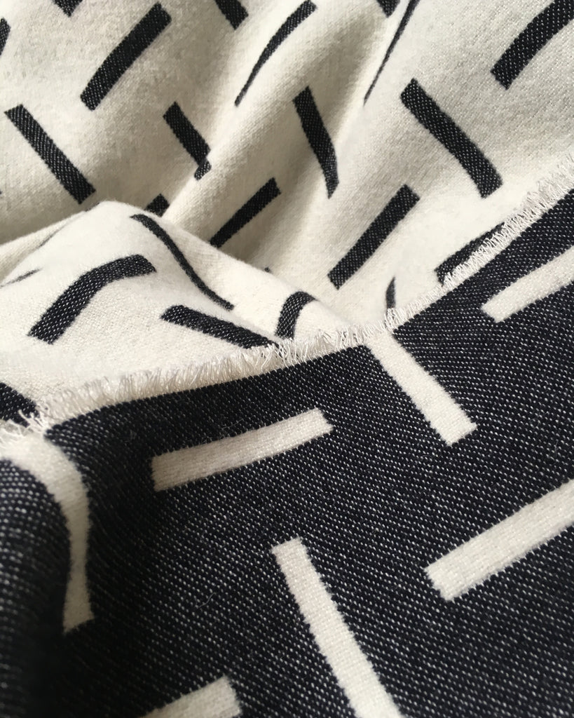 Monochrome, merino wool blanket. Contemporary, geometric design. Woven in England.